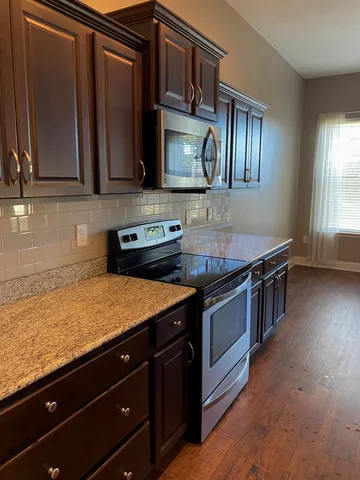 a kitchen with stainless steel appliances granite countertop a sink stove and microwave