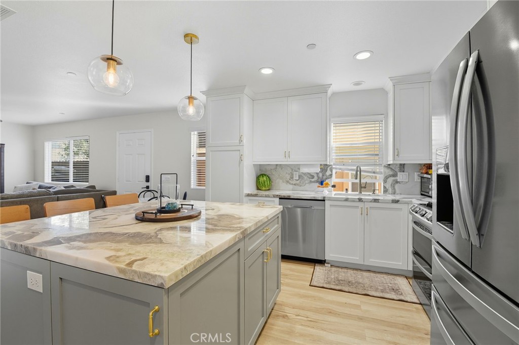 a kitchen with stainless steel appliances granite countertop a sink a stove and refrigerator