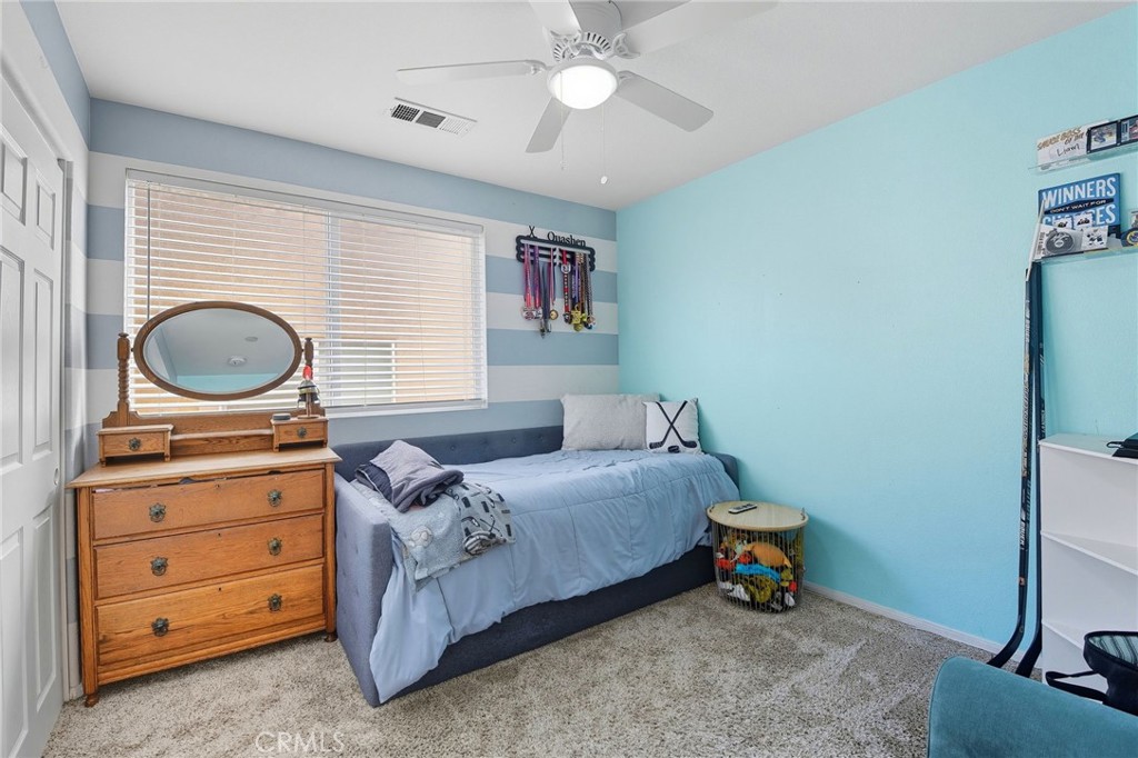 21711 Doss Place Saugus, CA 91350 - Photo 13 of 27 a bedroom with a bed and wooden cabinets