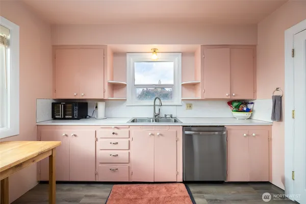 a kitchen with cabinets appliances a sink and a window