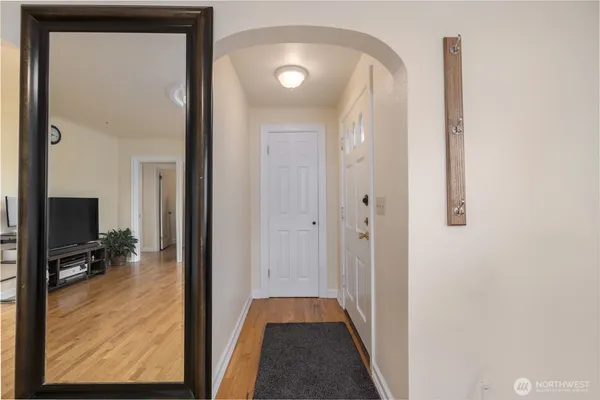 a view of a hallway with wooden floor and a living room
