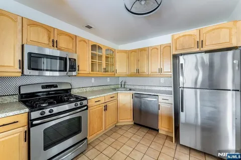 a kitchen with granite countertop a refrigerator stove and microwave