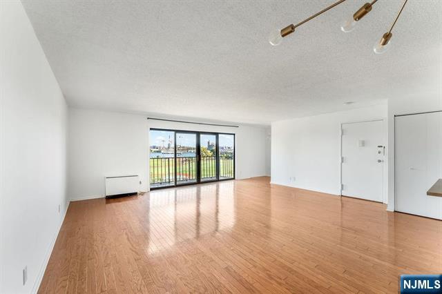 1150 River Road, Unit 4F Edgewater, NJ 07020 - Photo 3 of 22 a view of an empty room with wooden floor and a window