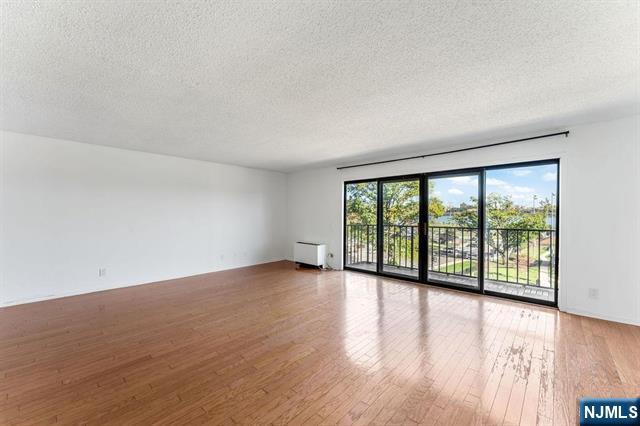 1150 River Road, Unit 4F Edgewater, NJ 07020 - Photo 5 of 22 wooden floor in an empty room with a window