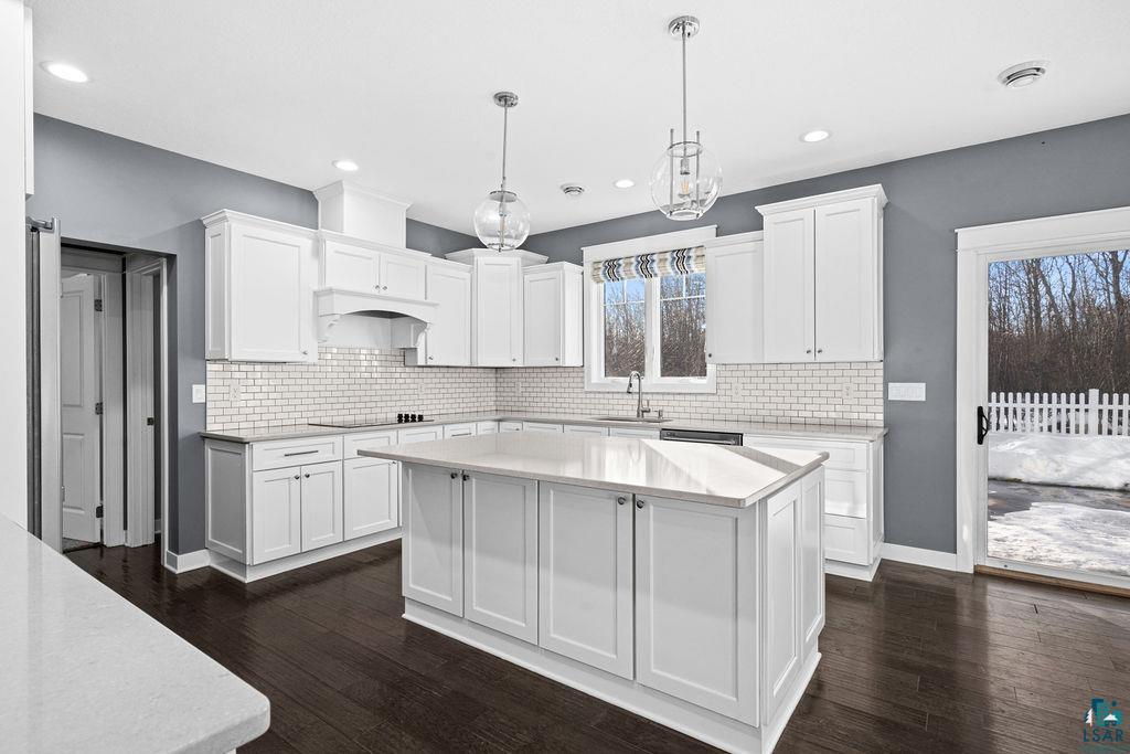 3879 Okerstrom Road Hermantown, MN 55811 - Photo 5 of 32 Kitchen featuring dark wood-type flooring, pendant lighting, white cabinets, and a center island
