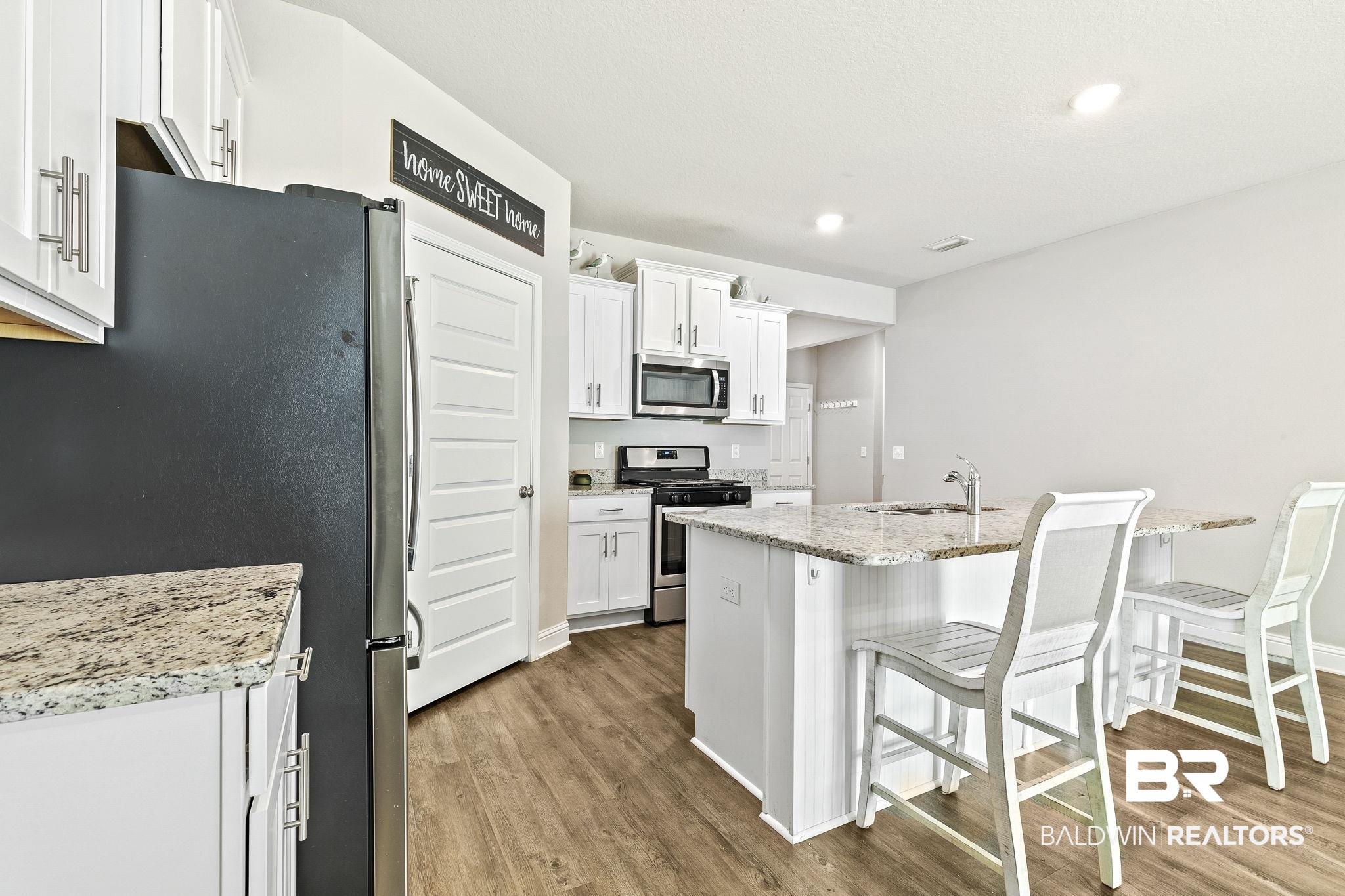 31610 Memphis Loop Daphne, AL 36527 - Photo 11 of 67 Kitchen featuring a breakfast bar, wood finished floors, appliances with stainless steel finishes, and a sink