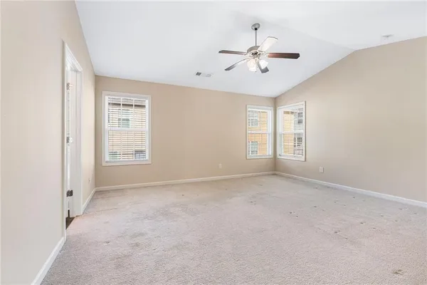 an empty room with windows and fan