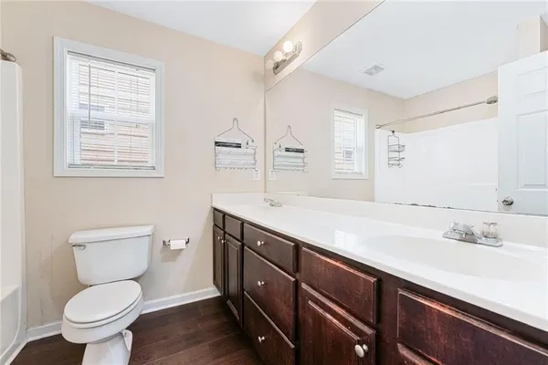 a spacious bathroom with a granite countertop toilet sink and a mirror