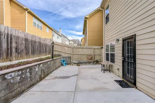 a view of a patio with table and chairs and wooden fence