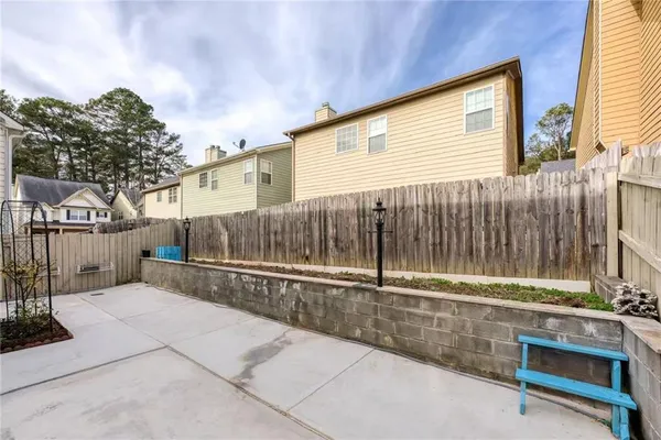 a view of backyard with wooden fence and large trees