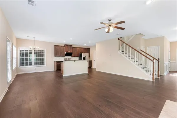 a view of a kitchen with wooden floor and a ceiling fan