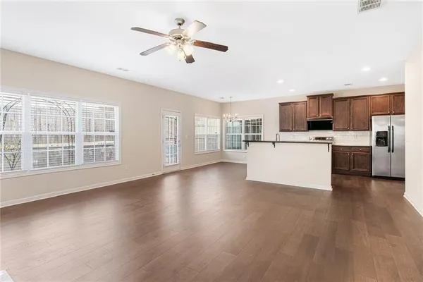 a view of a kitchen with a stove cabinets a ceiling fan and wooden floor