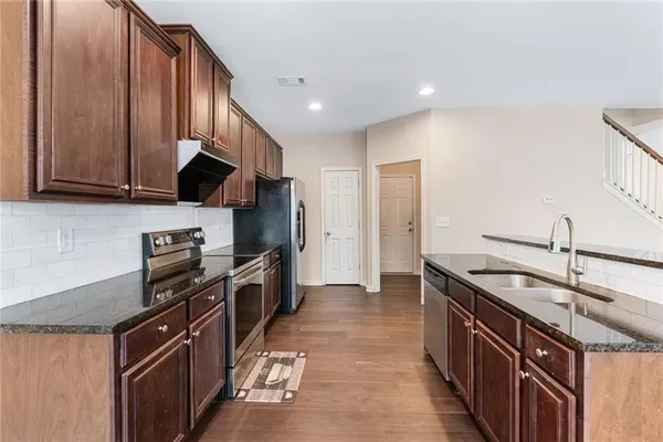 a kitchen with stainless steel appliances granite countertop a sink stove and refrigerator