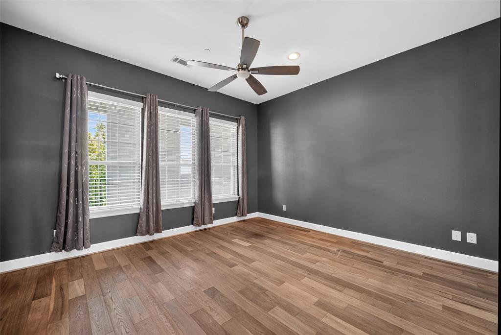5015 Meridian Lane, Unit 2102 Addison, TX 75001 - Photo 19 of 36 Spacious room featuring wood-finish flooring, dark-toned walls, and white trim