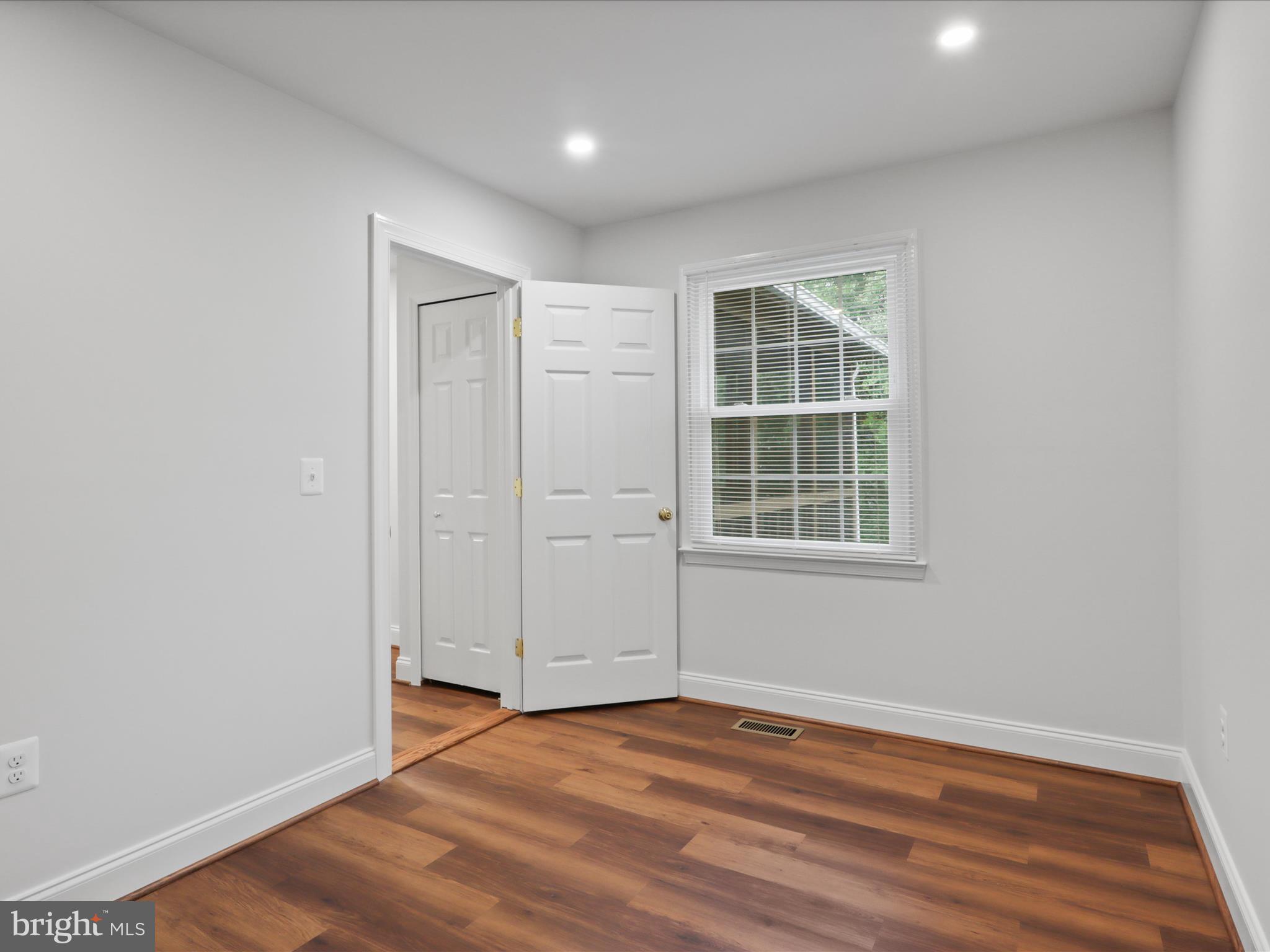 9365 River Crest Road Manassas, VA 20110 - Photo 26 of 62 an empty room with wooden floor and windows