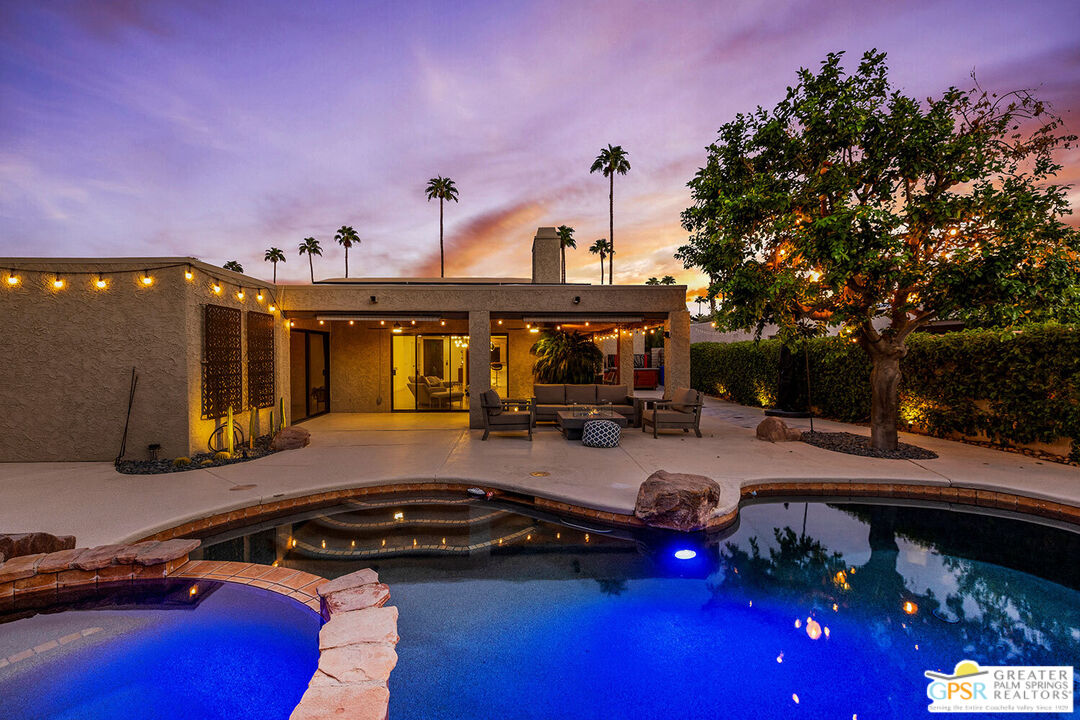 a view of a swimming pool and lounge chairs in the patio