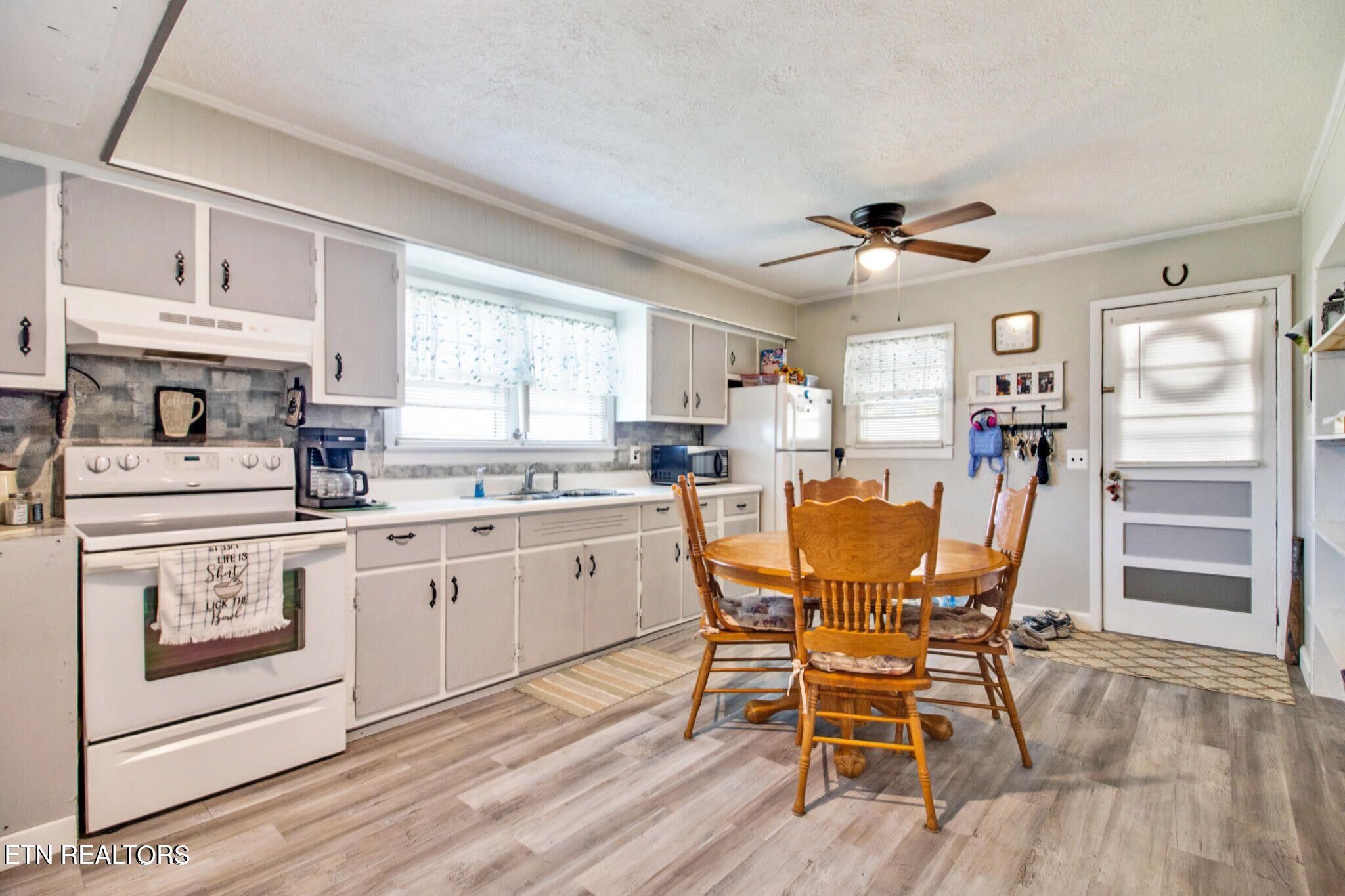 700 Rugby Avenue Jamestown, TN 38556 - Photo 16 of 24 a kitchen with stainless steel appliances granite countertop a stove top oven a sink dishwasher and white cabinets with wooden floor