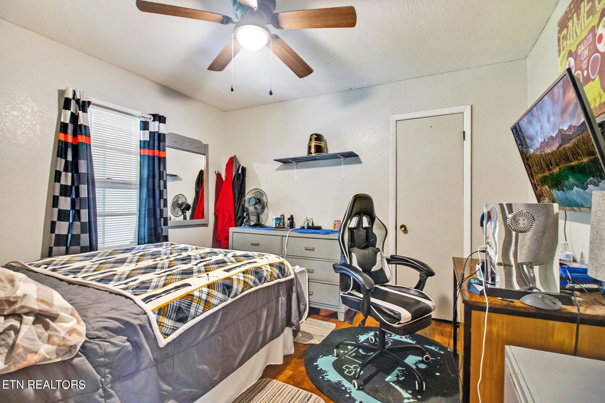 700 Rugby Avenue Jamestown, TN 38556 - Photo 21 of 24 a bedroom with a bed and a flat tv screen on the dresser