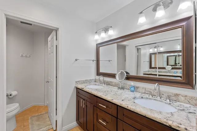 a bathroom with a granite countertop sink and a mirror