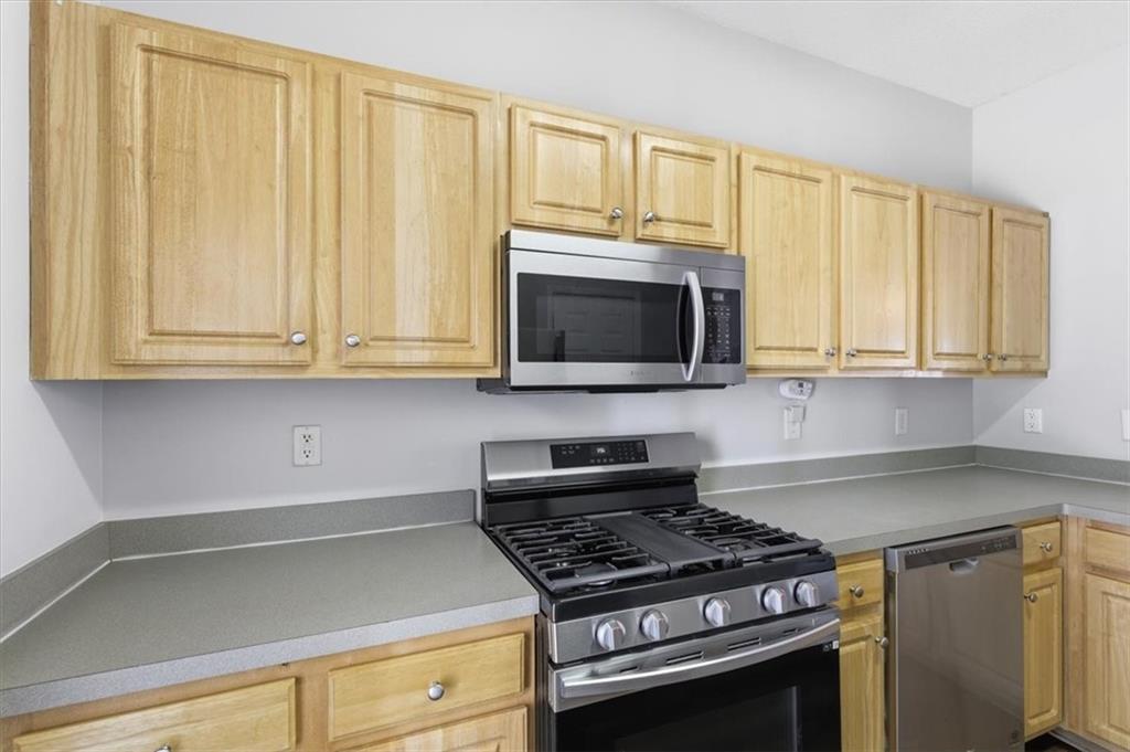 200 Riverstone Commons Circle Canton, GA 30114 - Photo 11 of 28 a kitchen with wooden cabinets and a stove top oven
