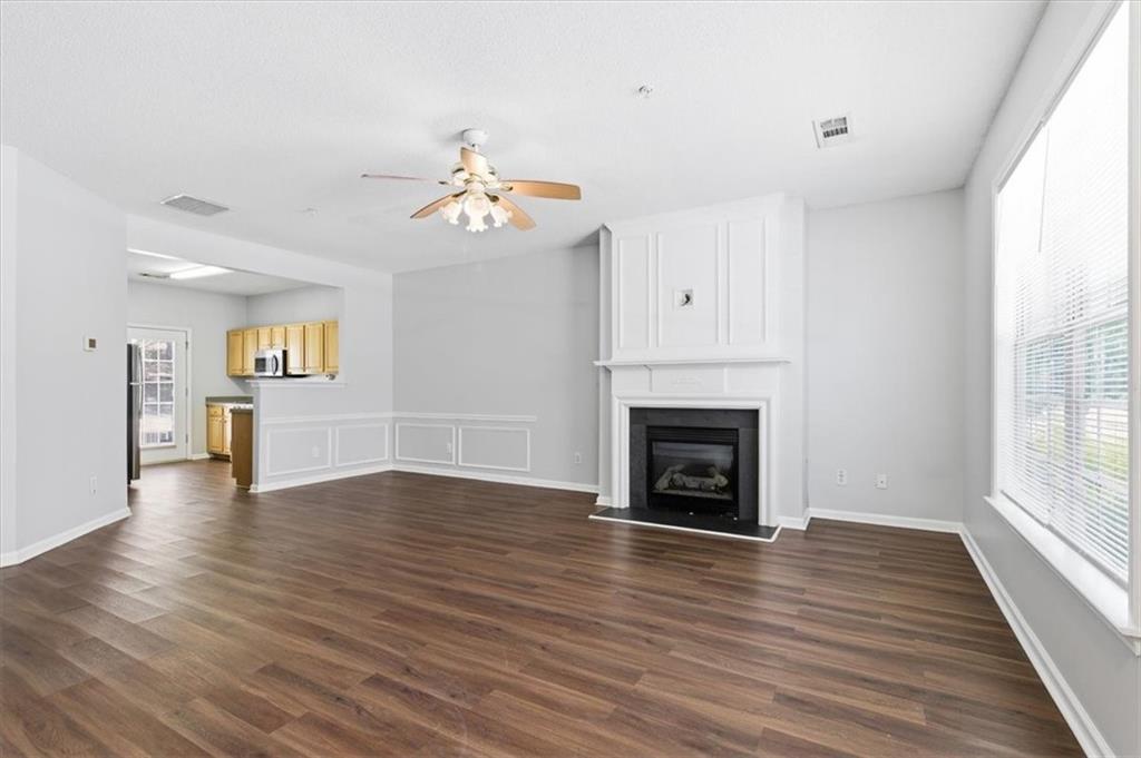 200 Riverstone Commons Circle Canton, GA 30114 - Photo 5 of 28 a view of a livingroom with wooden floor a fireplace and windows