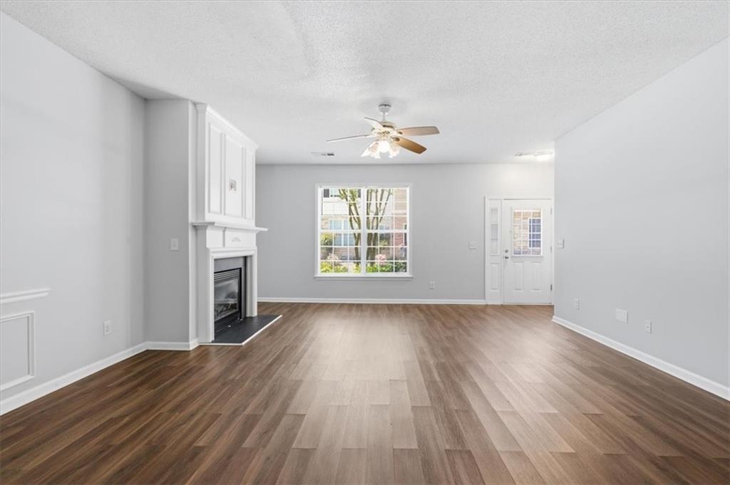 200 Riverstone Commons Circle Canton, GA 30114 - Photo 7 of 28 an empty room with wooden floor chandelier and windows
