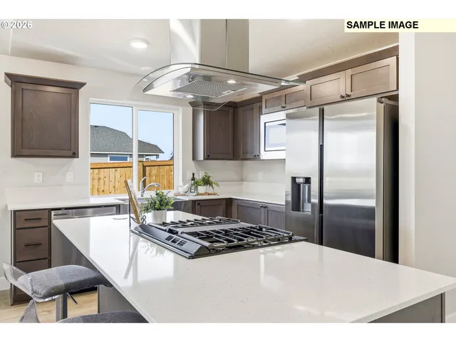 a kitchen with stainless steel appliances granite countertop a sink a stove a refrigerator and cabinets