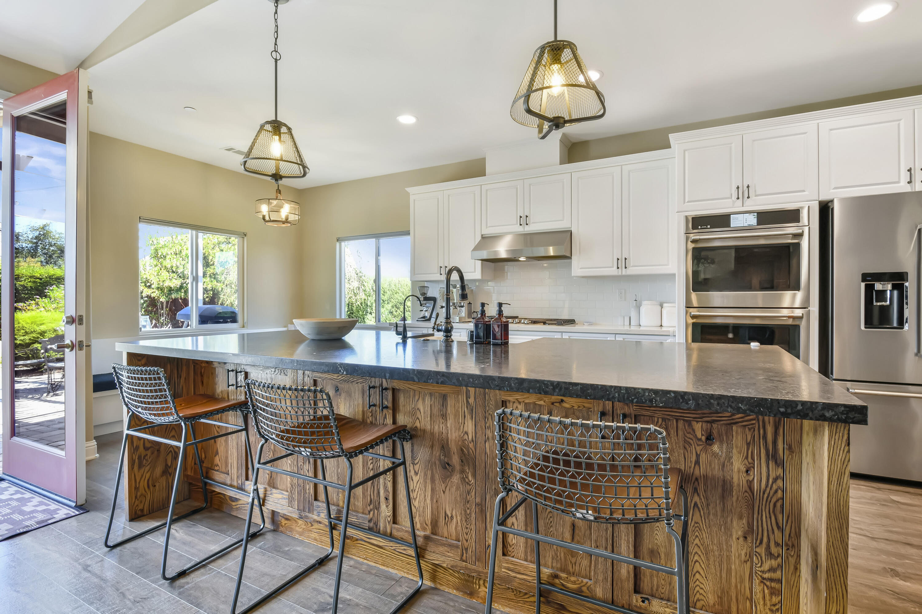585 Valley Oak Road Solvang, CA 93463 - Photo 3 of 21 a kitchen with stainless steel appliances a table chairs refrigerator and microwave