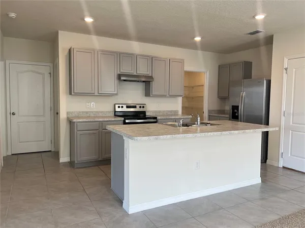 a kitchen with stainless steel appliances a sink stove refrigerator and cabinets