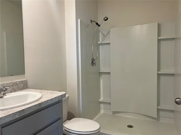 a bathroom with a granite countertop toilet sink and shower