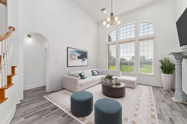 a living room with furniture a chandelier and a window