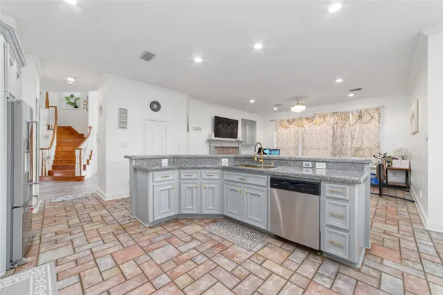 a large kitchen with stainless steel appliances lots of white cabinets