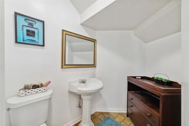 a bathroom with a sink toilet and a mirror