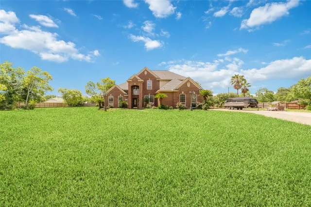 a view of a house with a big yard and large trees