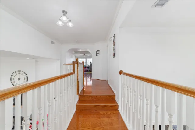 a view of a hallway with wooden floor and stairs