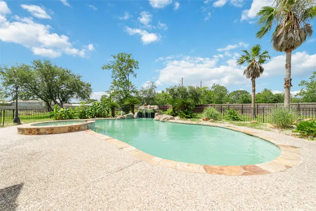 a view of a swimming pool with a yard and a fountain