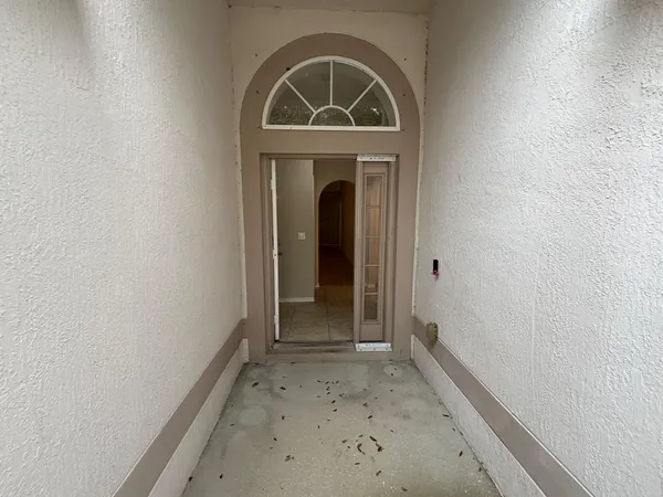 a view of a hallway with wooden floor and a window