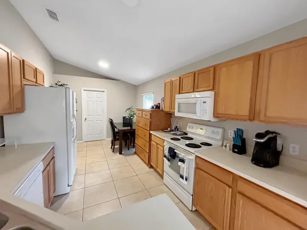 a kitchen with stainless steel appliances a stove a microwave a sink a refrigerator and cabinets