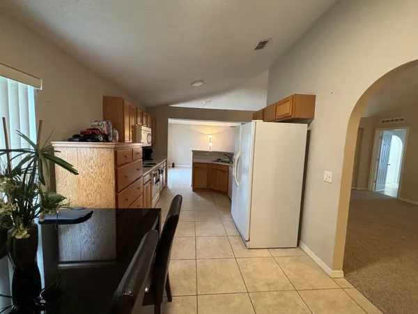 a view of a kitchen with fridge and workspace