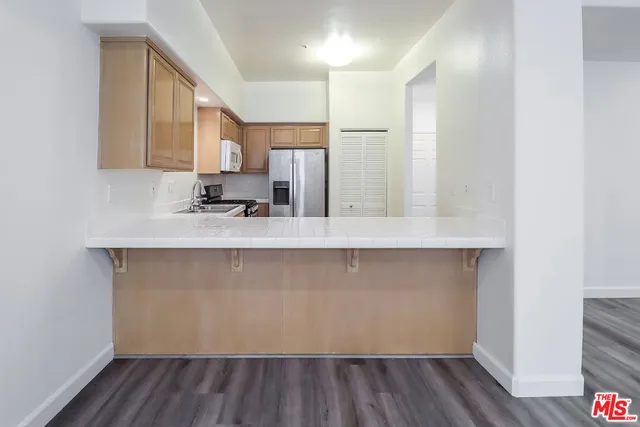 a kitchen with stainless steel appliances granite countertop a refrigerator sink and stove