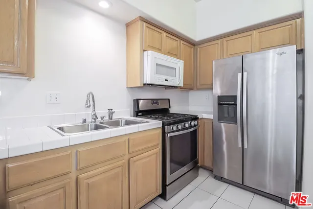 a white refrigerator freezer and a stove sitting inside of a kitchen