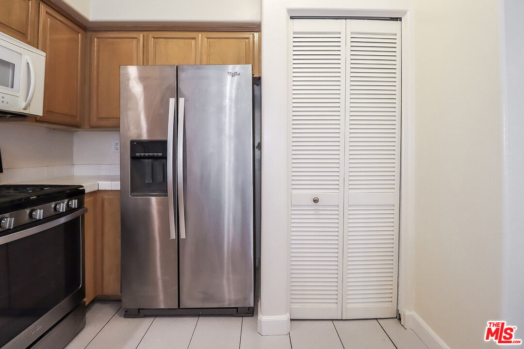 11920 Goshen Avenue, Unit 102 Los Angeles, CA 90049 - Photo 14 of 39 a kitchen with stainless steel appliances a refrigerator and a stove