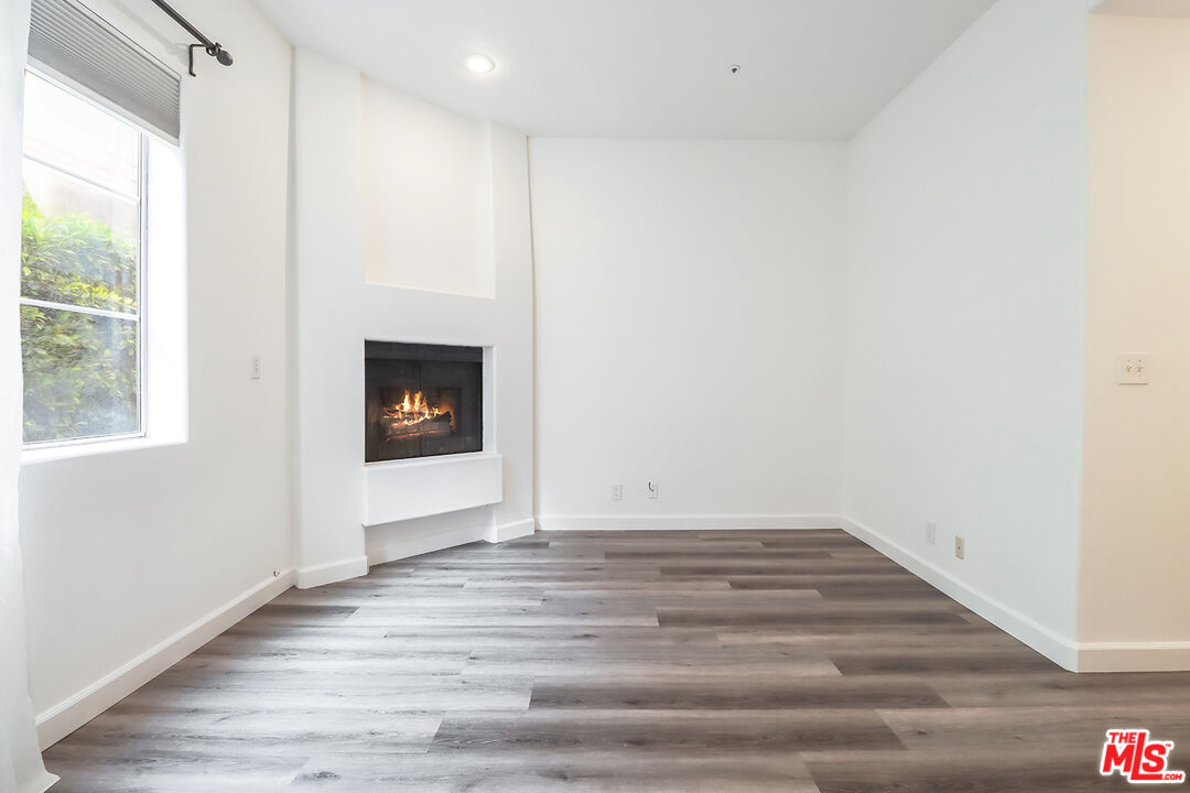 11920 Goshen Avenue, Unit 102 Los Angeles, CA 90049 - Photo 27 of 39 a view of an empty room with wooden floor and a window