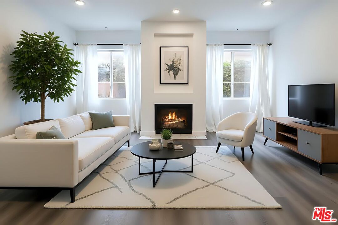 11920 Goshen Avenue, Unit 102 Los Angeles, CA 90049 - Photo 3 of 39 a living room with furniture a flat screen tv and a fireplace