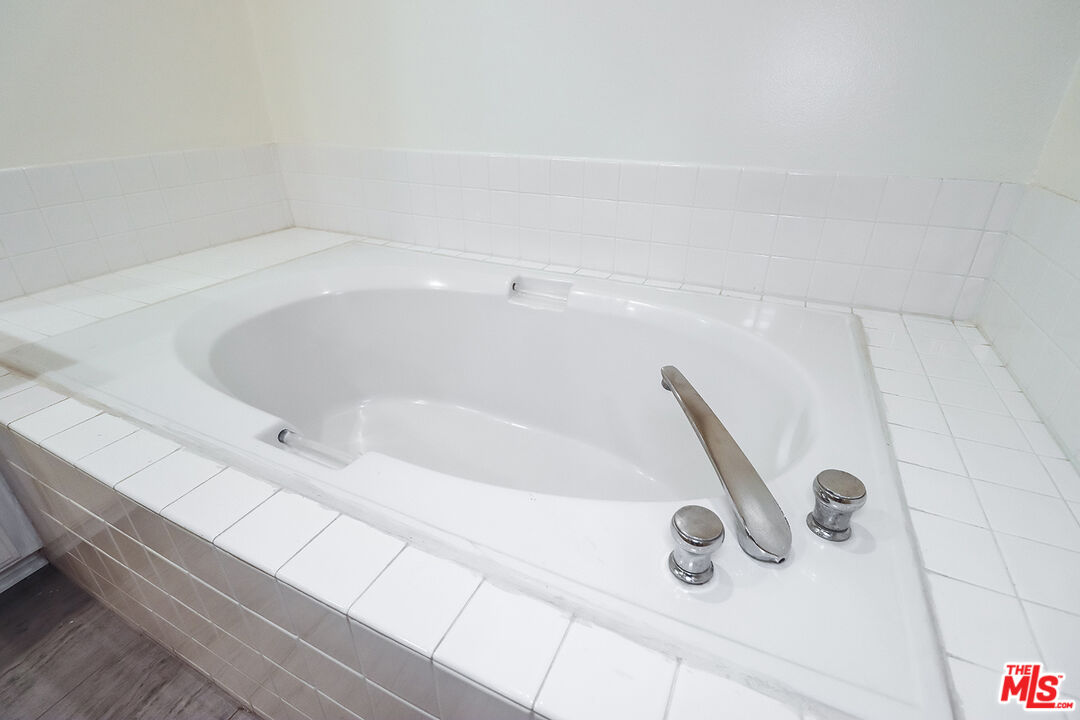 11920 Goshen Avenue, Unit 102 Los Angeles, CA 90049 - Photo 32 of 39 a bath tub sitting next to a white sink and a stove