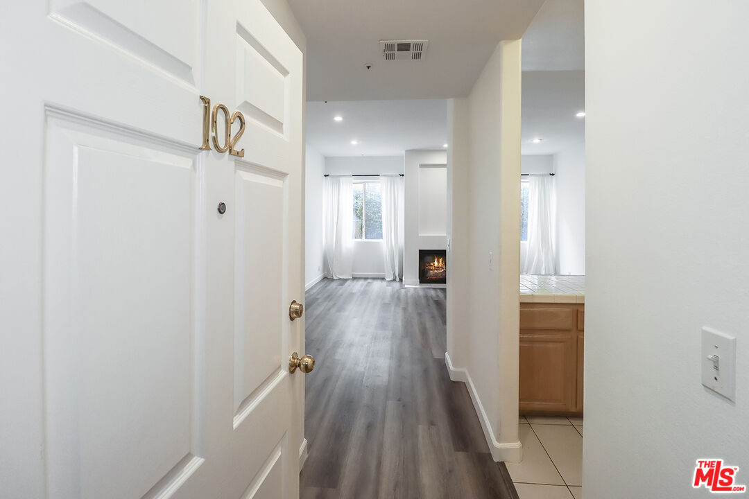 11920 Goshen Avenue, Unit 102 Los Angeles, CA 90049 - Photo 4 of 39 a view of a hallway with wooden floor and staircase
