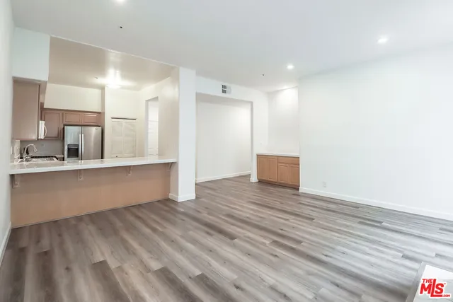 a view of a kitchen with wooden floor and electronic appliances