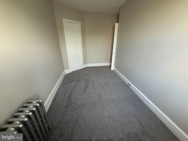 a view of a hallway with wooden floor and stairs