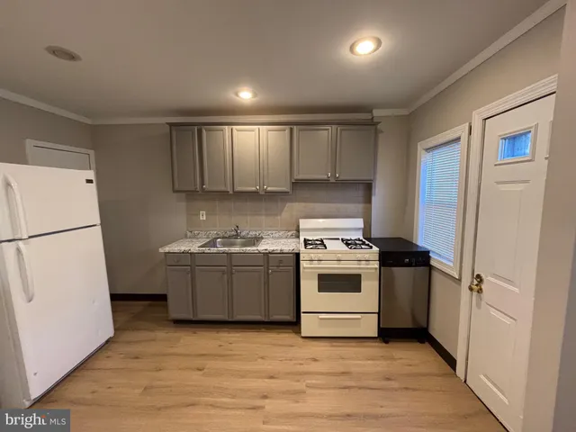 a kitchen with a stove a refrigerator and a sink