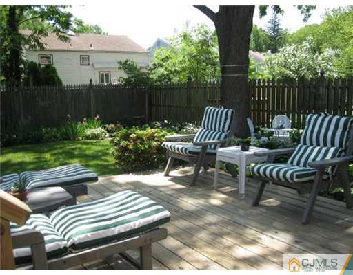 196 North Hill Road Colonia, NJ 07067 - Photo 4 of 10 a view of a patio with lawn chairs next to a yard